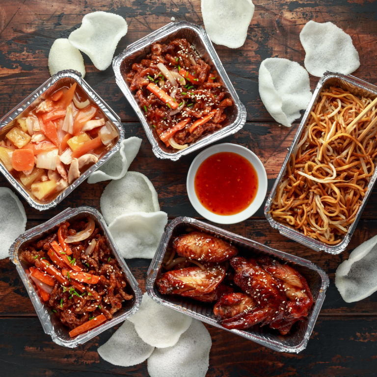 A range of delicious Chinese food including crispy chilli chicken, chicken wings, noodles and sweet and sour chicken and prawn crackers